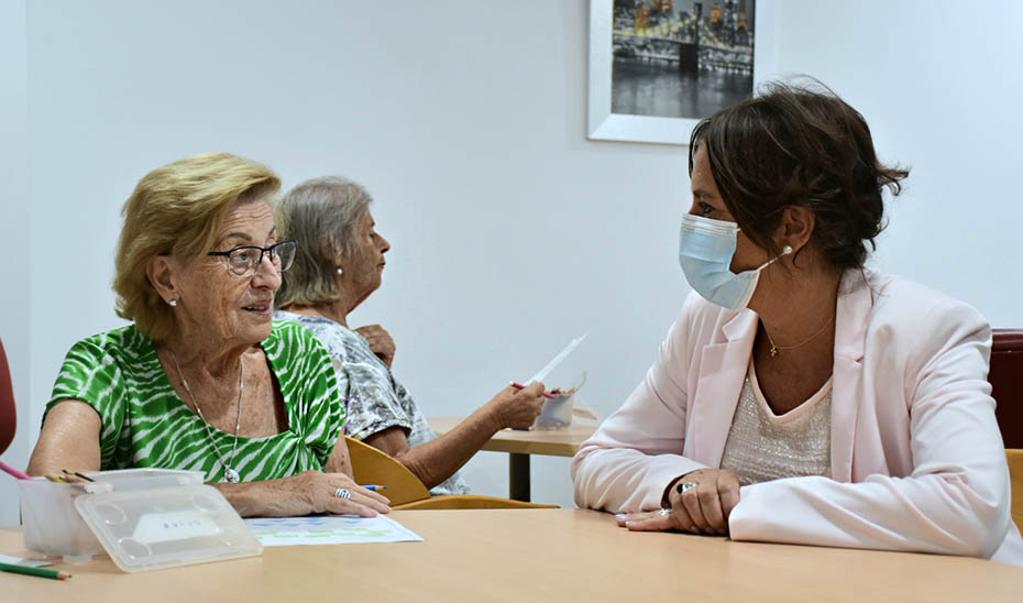 
			      La consejera de Salud, Catalina García, conversa con una usuaria del centro de día de AFA Vitae en San Fernando.			    
			  